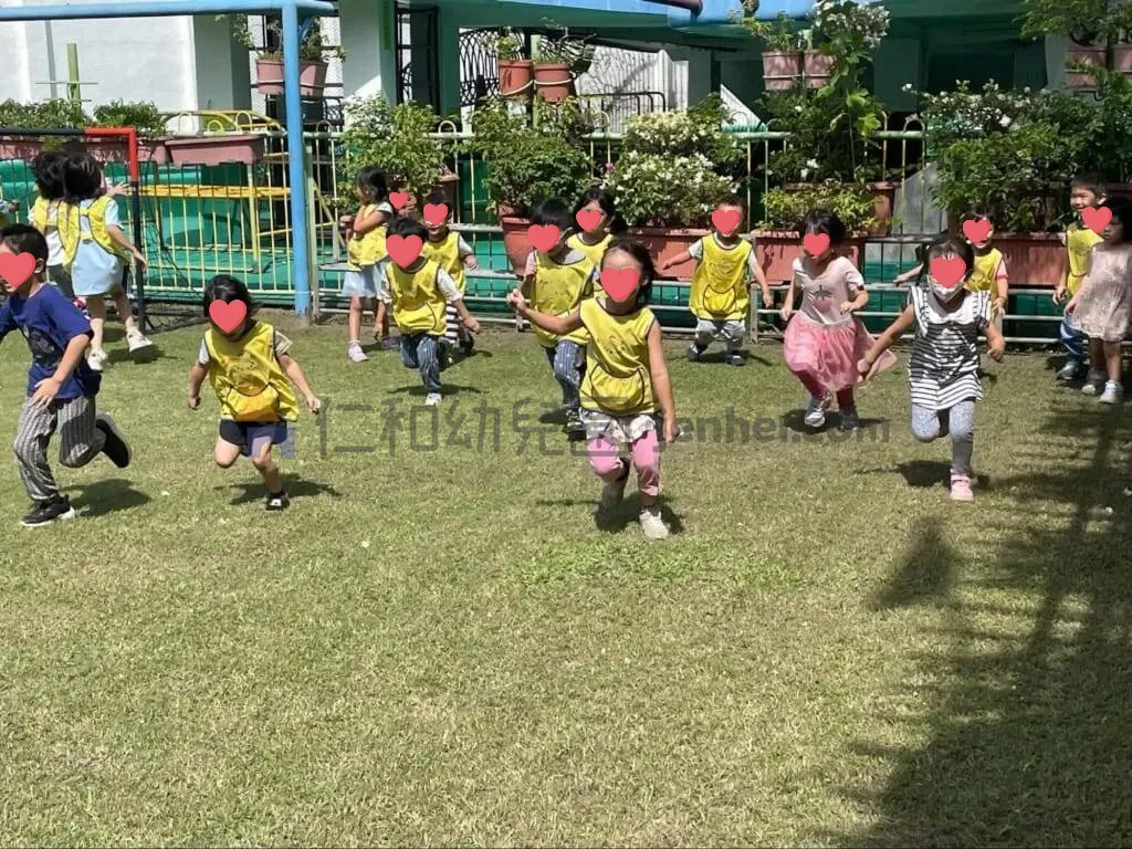 幼兒在戶外草地進行跑步追逐遊戲，練習移動與身體協調